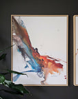 Framed abstract artwork of a Phoenix by Lotta Sirén on a dark wall with a plant in the foreground