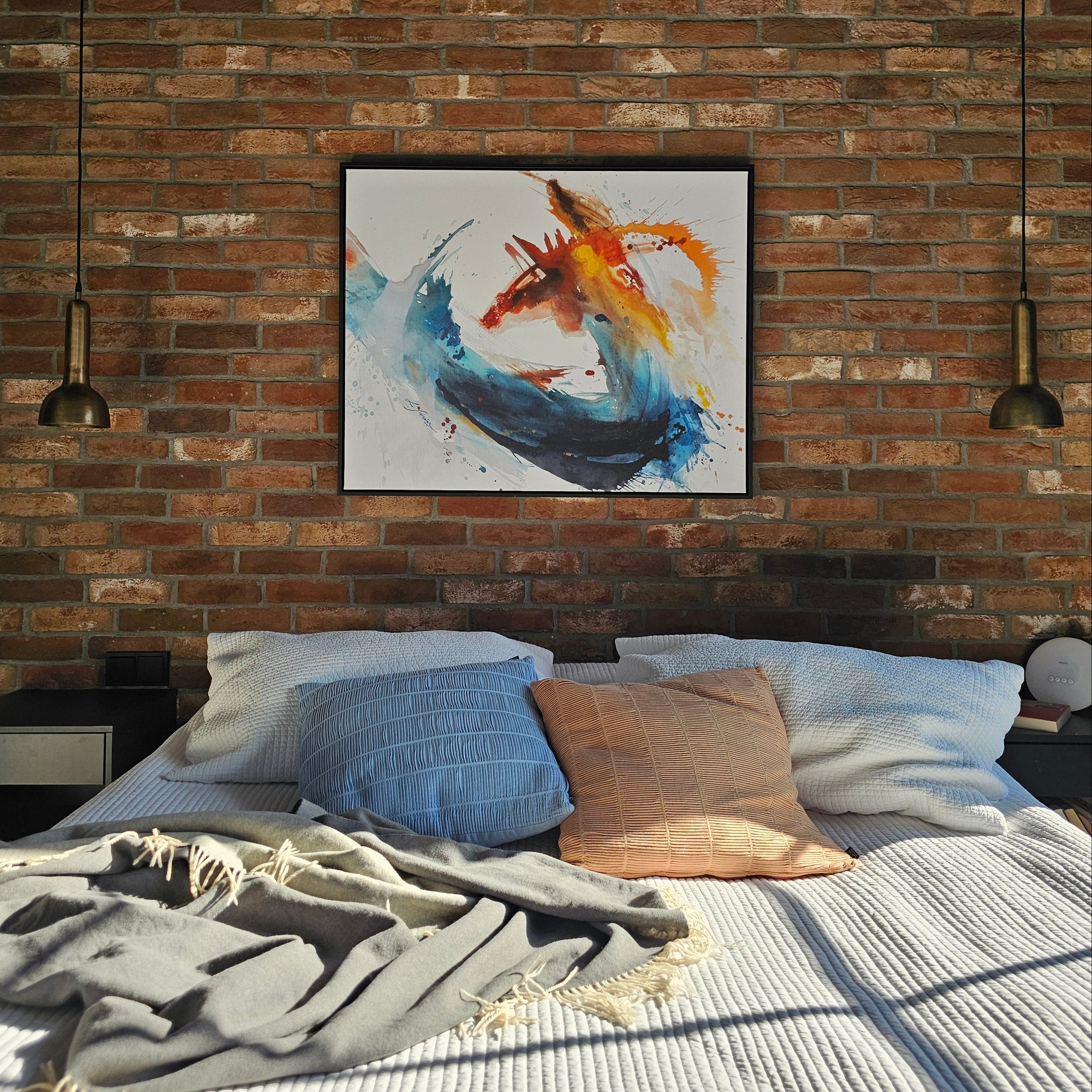 Colorful abstract art print of Dragon by Lotta Sirén on a brick wall next to a bed with pillows and blankets.