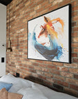 Abstract painting "Dragon" with black frames by Lotta Sirén on a brick wall above a bed