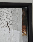 Empowering abstract art piece by Lotta Sirén with cracked texture and black frame on a white wall