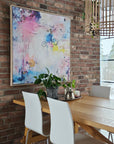 Colorful abstract painting on a brick wall with modern furniture and decor.