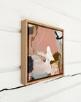 Framed abstract art piece on a white wooden wall by abstract artist Lotta Sirén