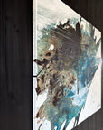 Close up of an abstract art piece by Finnish artist Lotta Sirén with black, blue, and white colors on a wall.