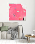 I Don't Like Pink - Limited Edition Canvas Print Print on a wall above a couch. An Abstract canvas print with bright pink bold strokes and hues of orange, blue and green. Off-white background with black details.