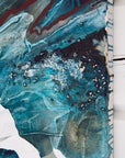 Abstract art piece with blue, black, and white colors on a textured surface.