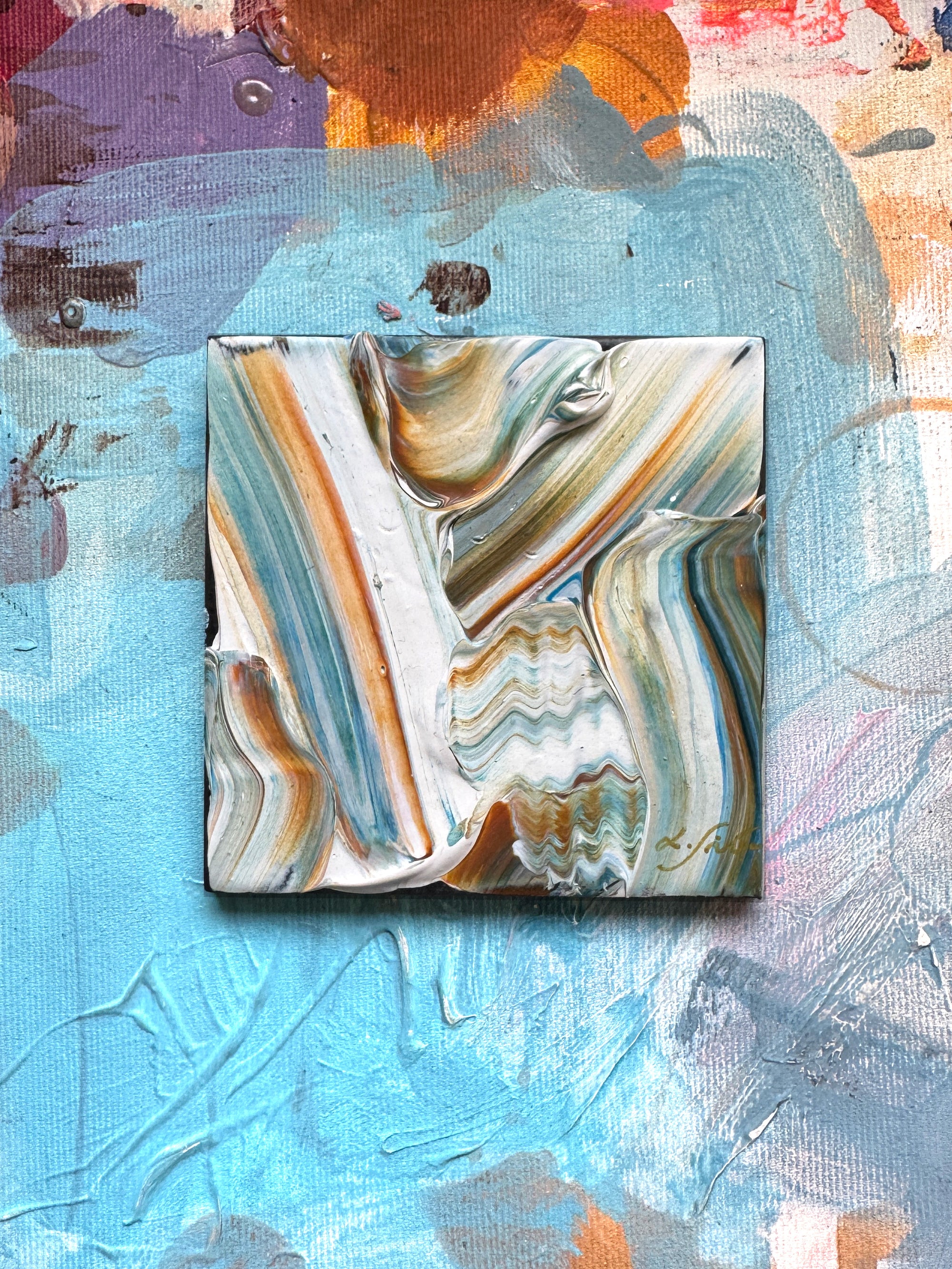 A ceramic abstract art piece with flowy creamy texture and turquoise, white and beige colors.
