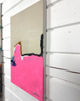 A side of an abstract painting with pink and black elements on a white wall
