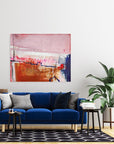 Modern living room with a blue sofa, abstract painting by Lotta Sirén, and decorative items.