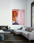Modern living room with a gray sectional sofa, abstract painting, and white brick wall.
