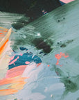 Close-up of an abstract art with splashes of green, orange, and black on a textured surface.
