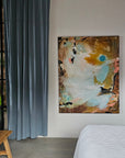 Abstract painting by Lotta Sirén on a wall above a bed in a modern bedroom with a glass wall.