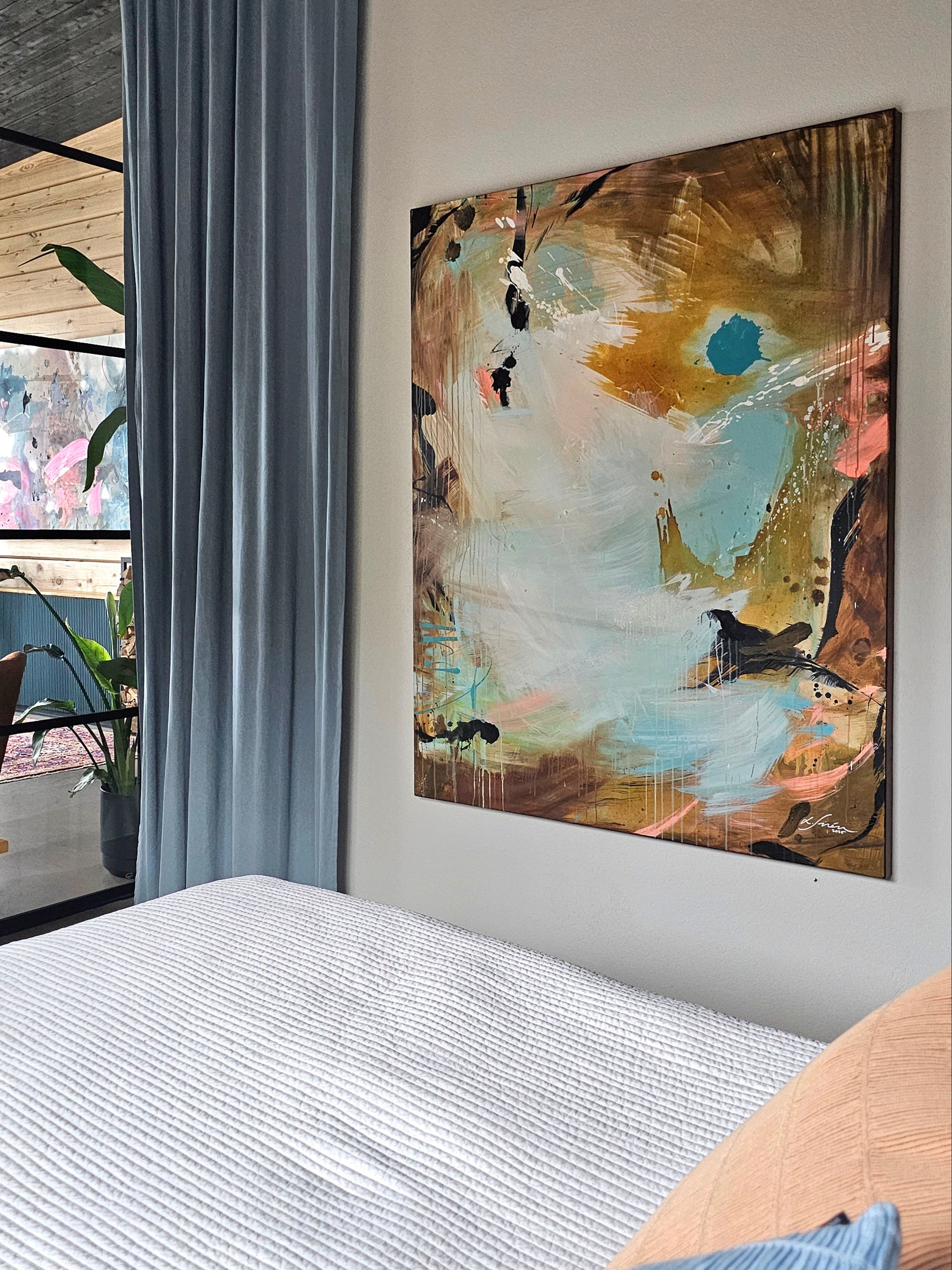 Abstract painting by Lotta Sirén on a wall above a bed in a modern bedroom with a glass wall.