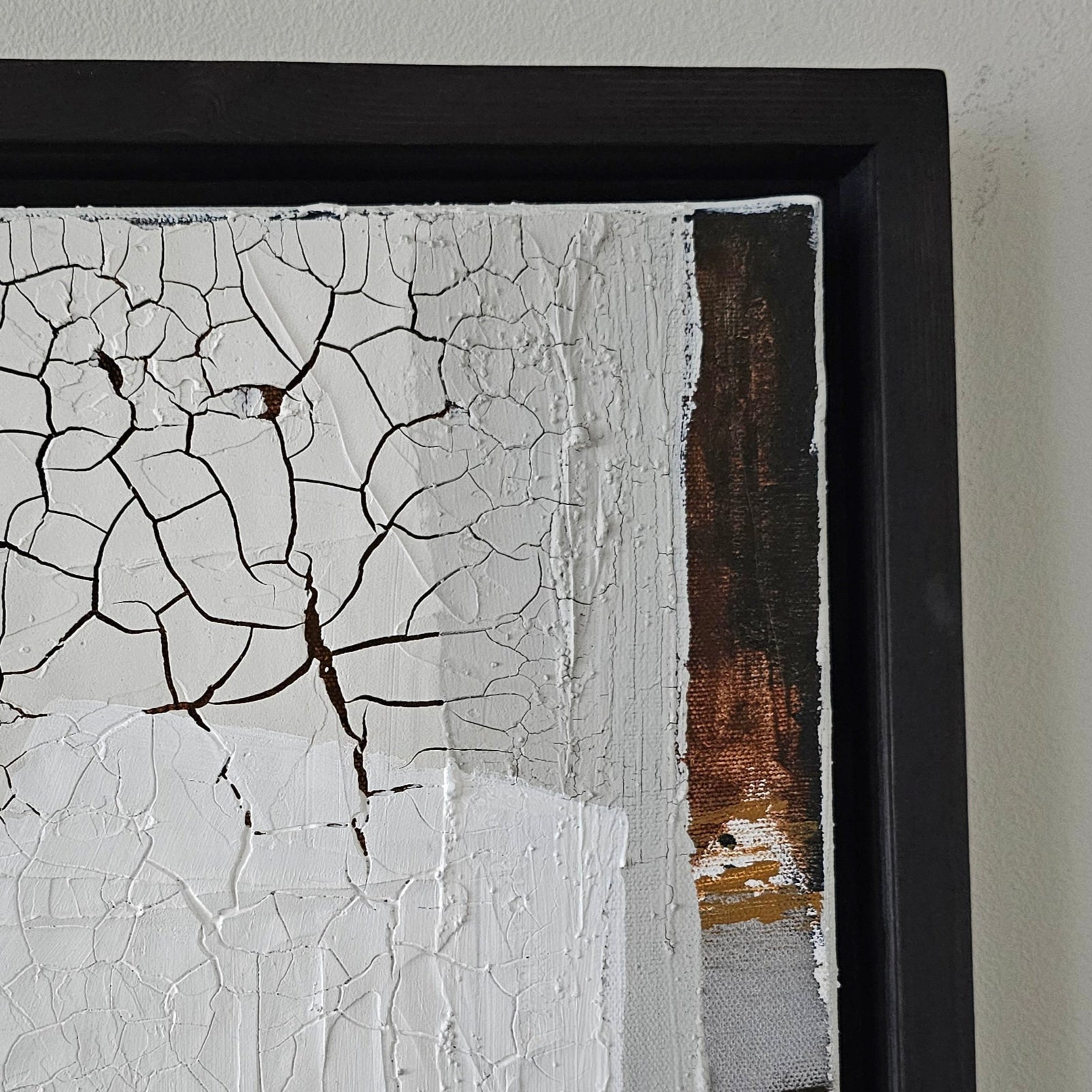 Empowering abstract art piece by Lotta Sirén with cracked texture and black frame on a white wall