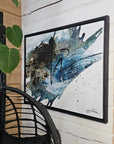 Black floater frames and abstract art piece by Finnish artist Lotta Sirén with black, blue, and white colors on a wall.