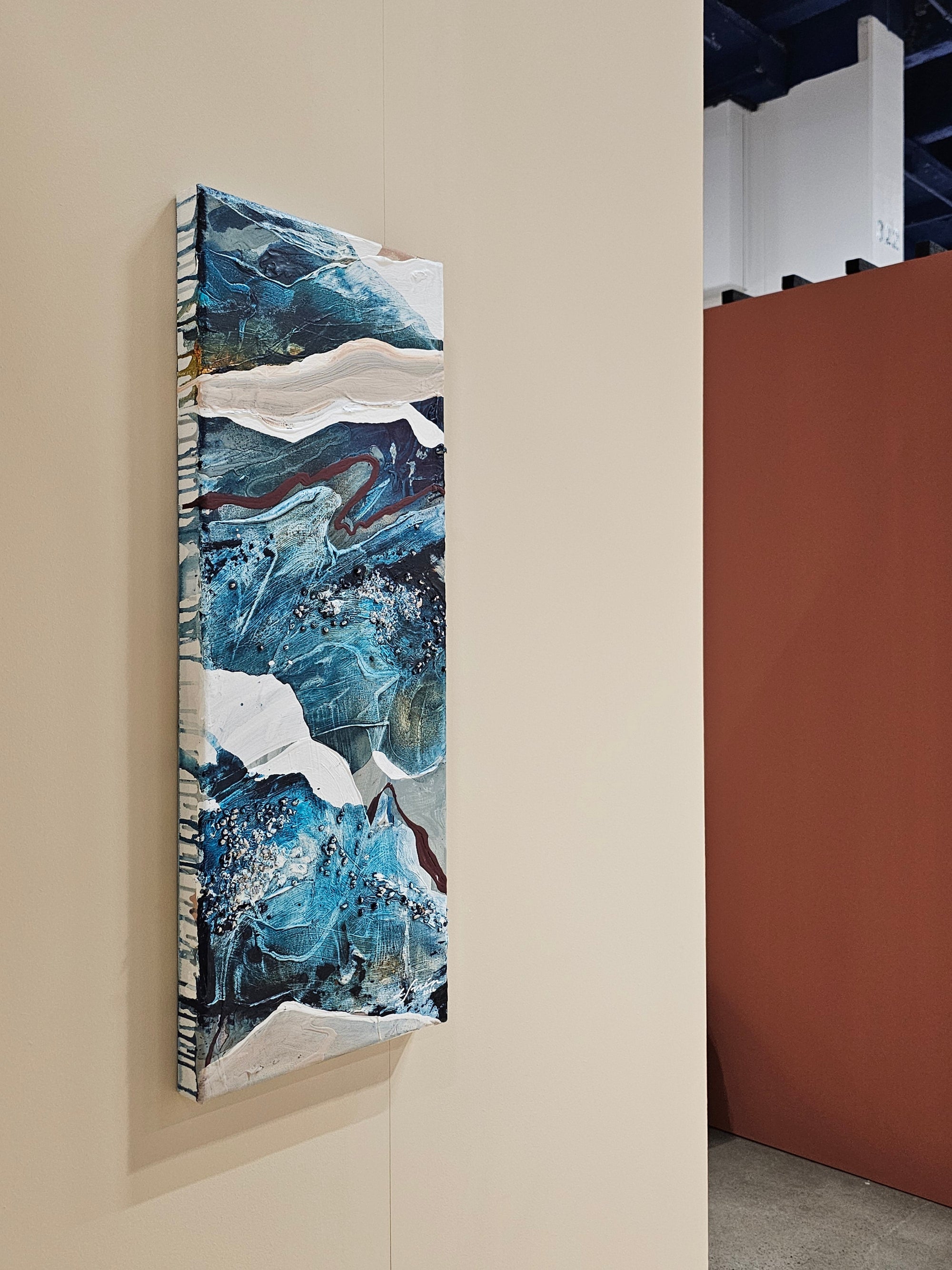 Blue abstract artwork on a beige wall in Kevätmessut 2026