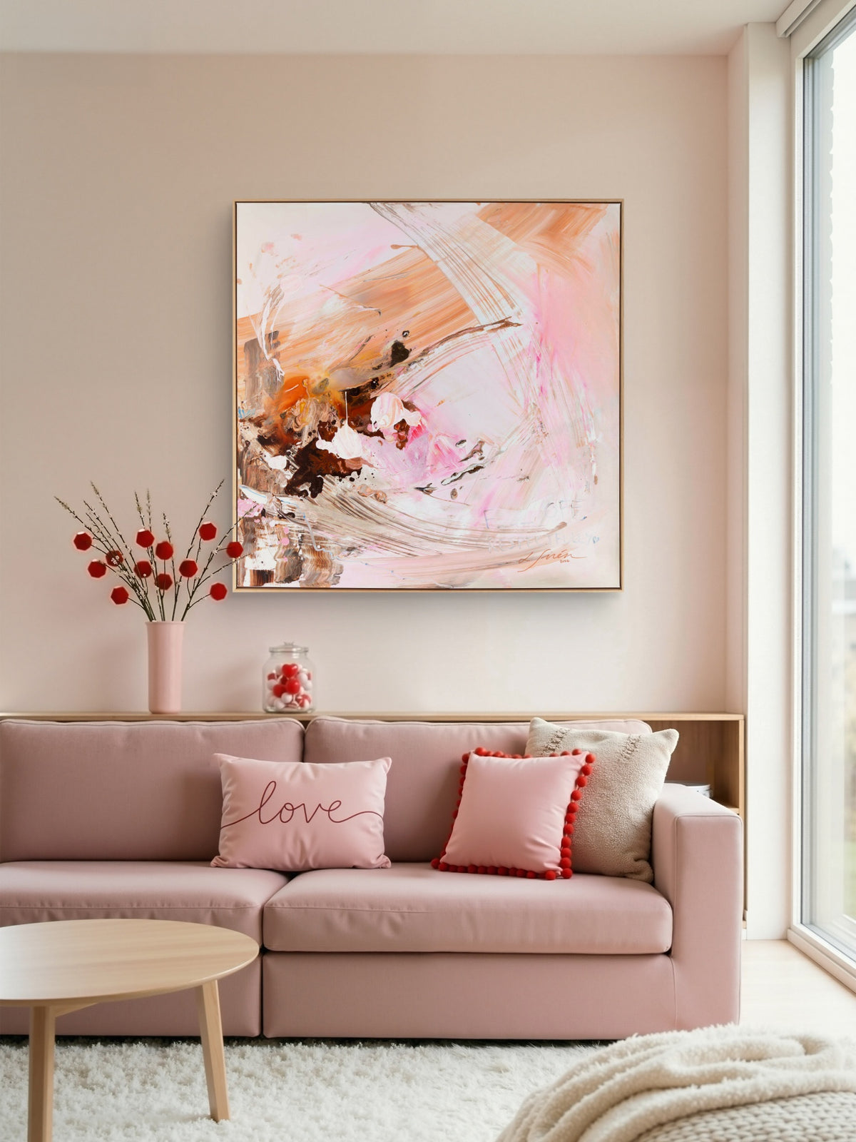 An abstract painting with pink, peach, white, and brown brushstrokes hanging on a beige wall above a pink sofa in a bright, modern living room.