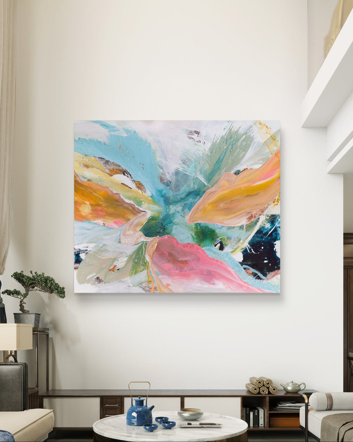 An abstract canvas wall art featuring a vibrant butterfly-like design in shades of pink, teal, yellow, orange, and green, displayed on a white wall in a modern living room setting.