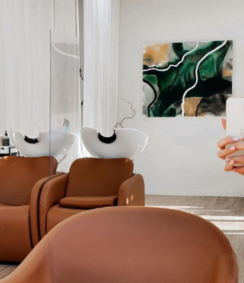 Modern interior with brown chairs and a abstract painting by Lotta Sirén on the wall.