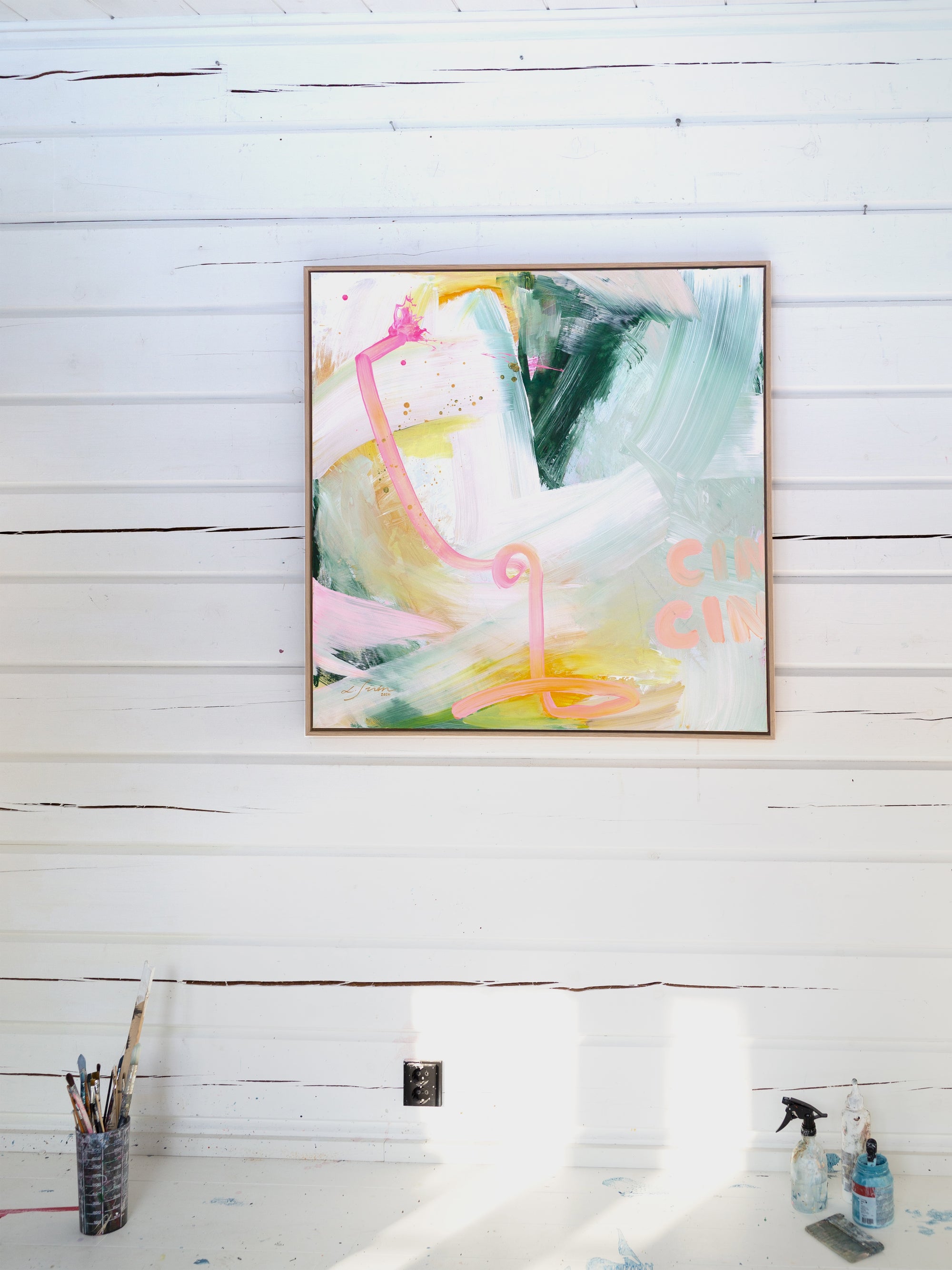 Abstract painting on a white wooden wall with art supplies below by Finnish abstract artist Lotta Sirén