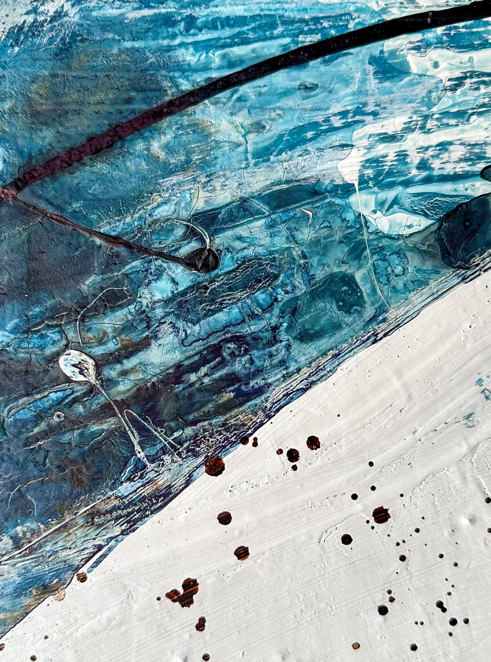 Close up of an abstract art piece by Finnish artist Lotta Sirén with black, blue, and white colors on a wall.