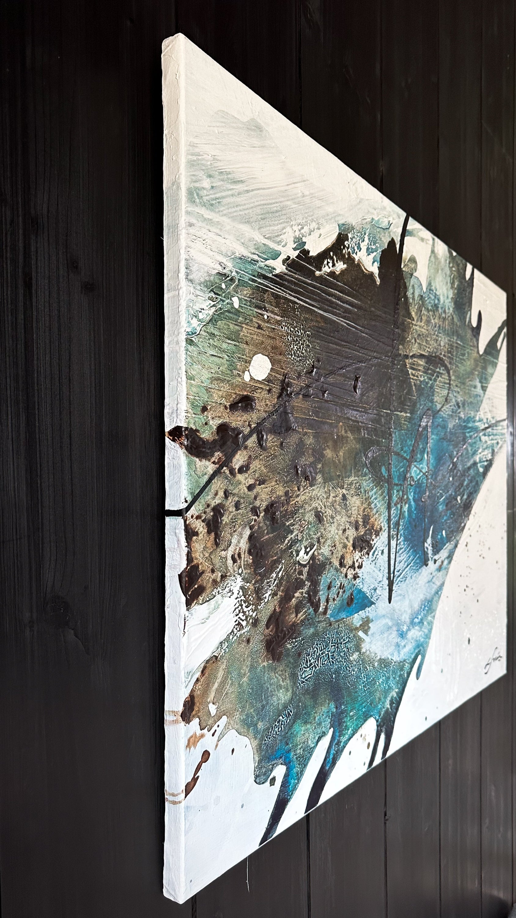 Close up of an abstract art piece by Finnish artist Lotta Sirén with black, blue, and white colors on a wall.