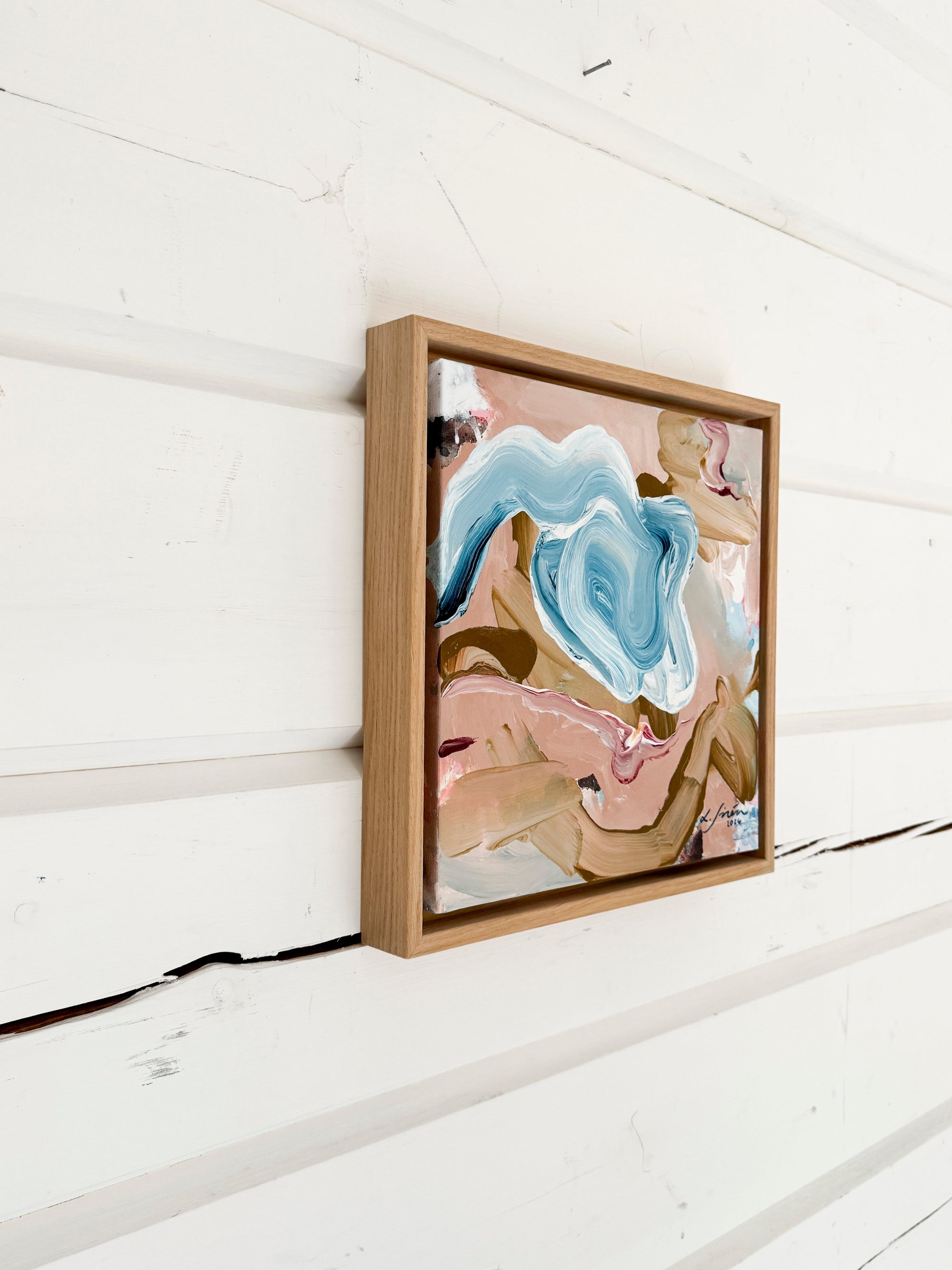 Framed abstract artwork on a white wooden wall by Finnish artist Lotta Sirén
