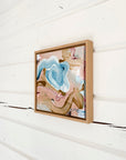 Framed abstract art piece on a white wooden wall by Finnish artist Lotta Sirén