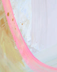 Close-up of an abstract painting with  pink and yellow hues on a textured white background