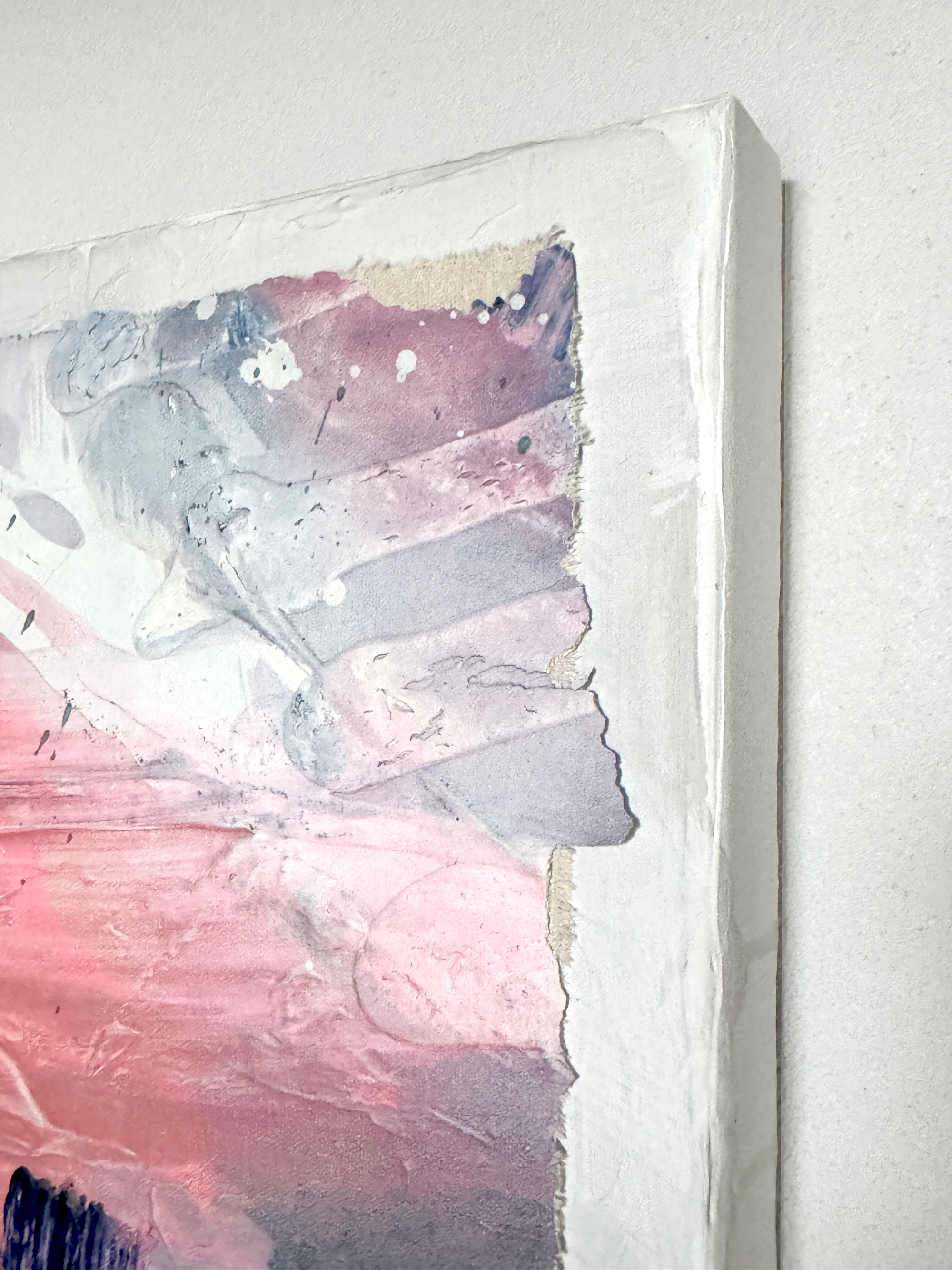 Abstract painting with pink and blue tones on a white wall