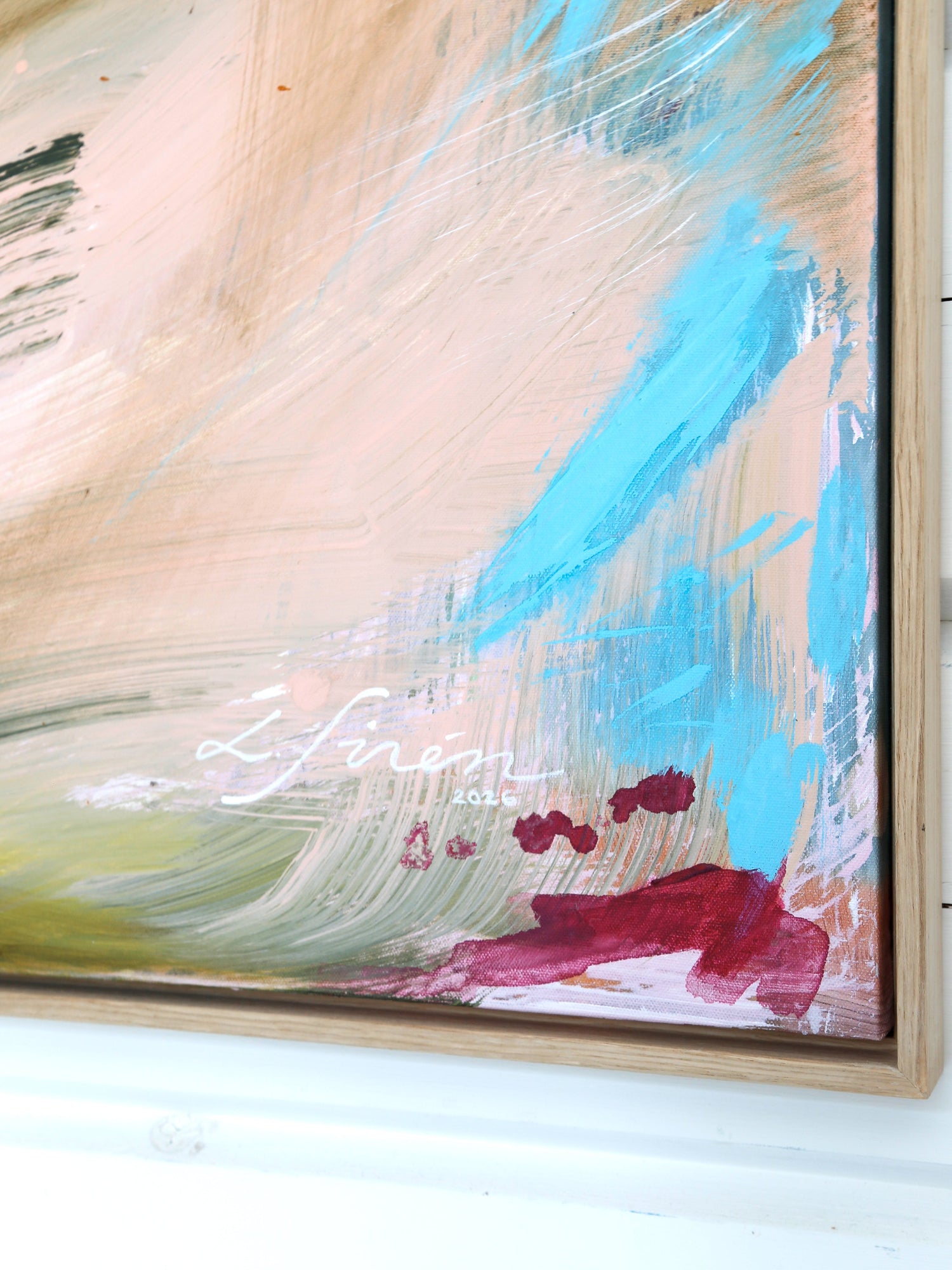 Colorful abstract painting with signature by Finnish emerging artist Lotta Sirén on a white wall. Oak floater frame.