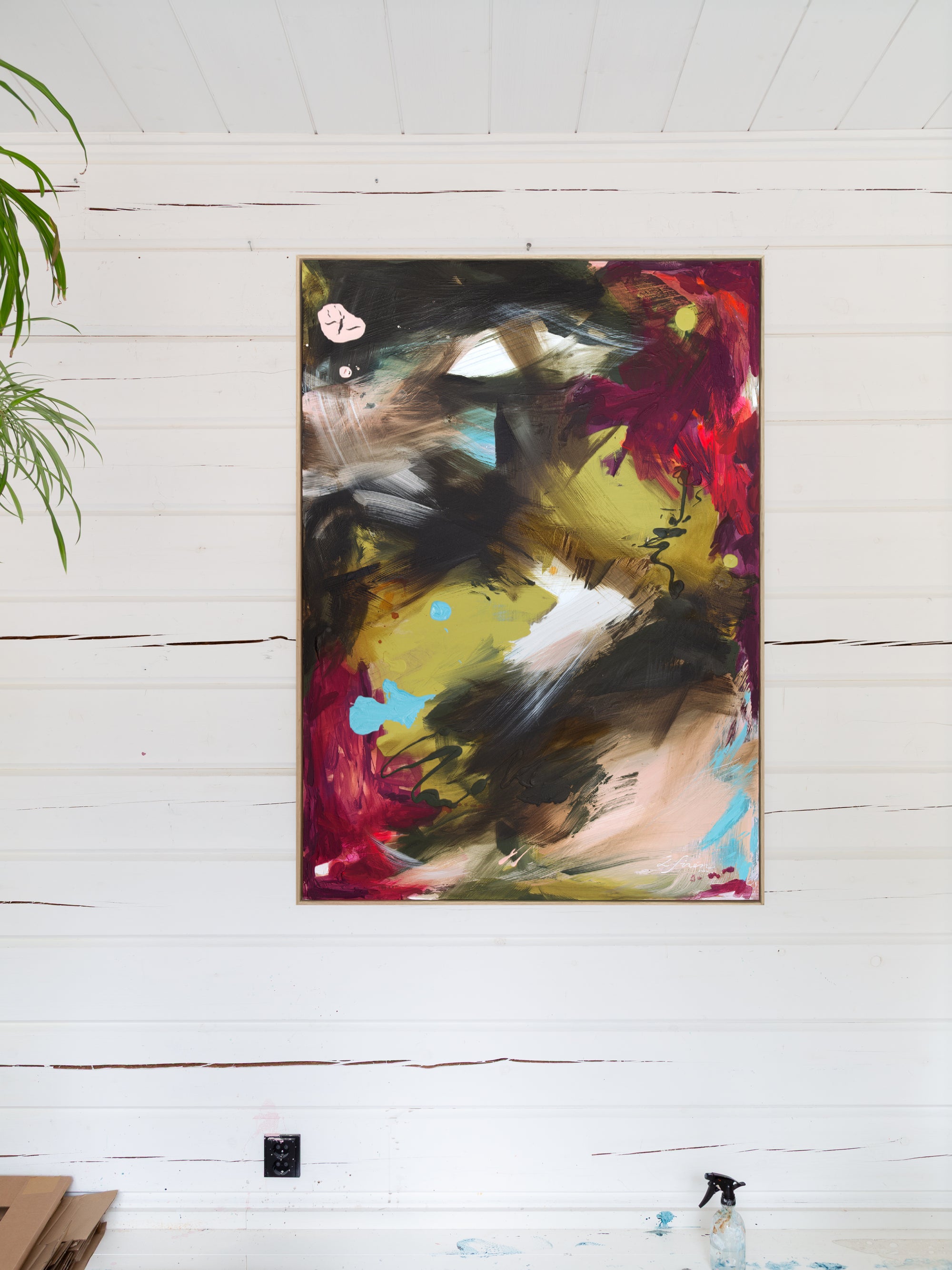 Abstract painting in Lotta Sirén Art studio on a white wall with a plant to the left