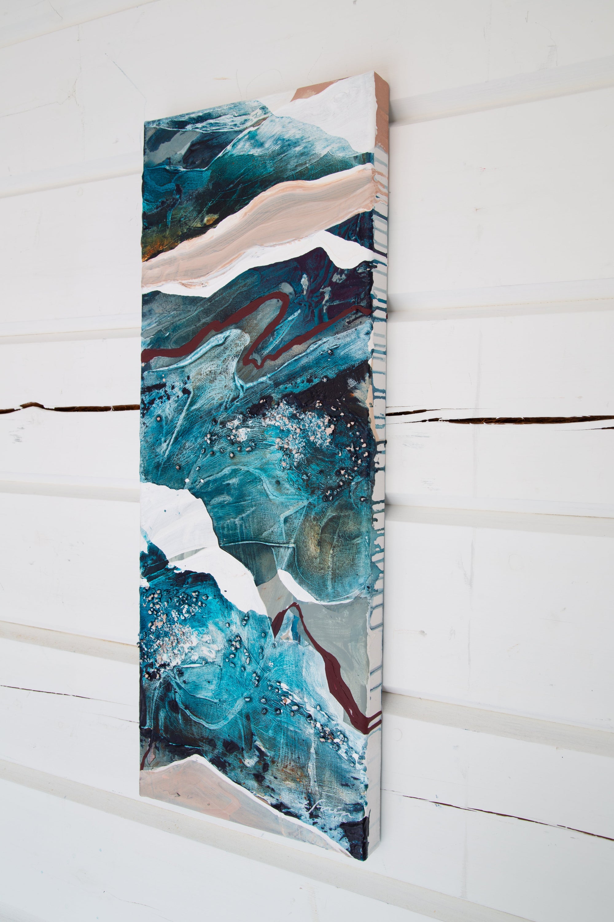Abstract art piece with blue and white colors on a wooden panel against a white wooden background by Finnish abstract artist Lotta Sirén