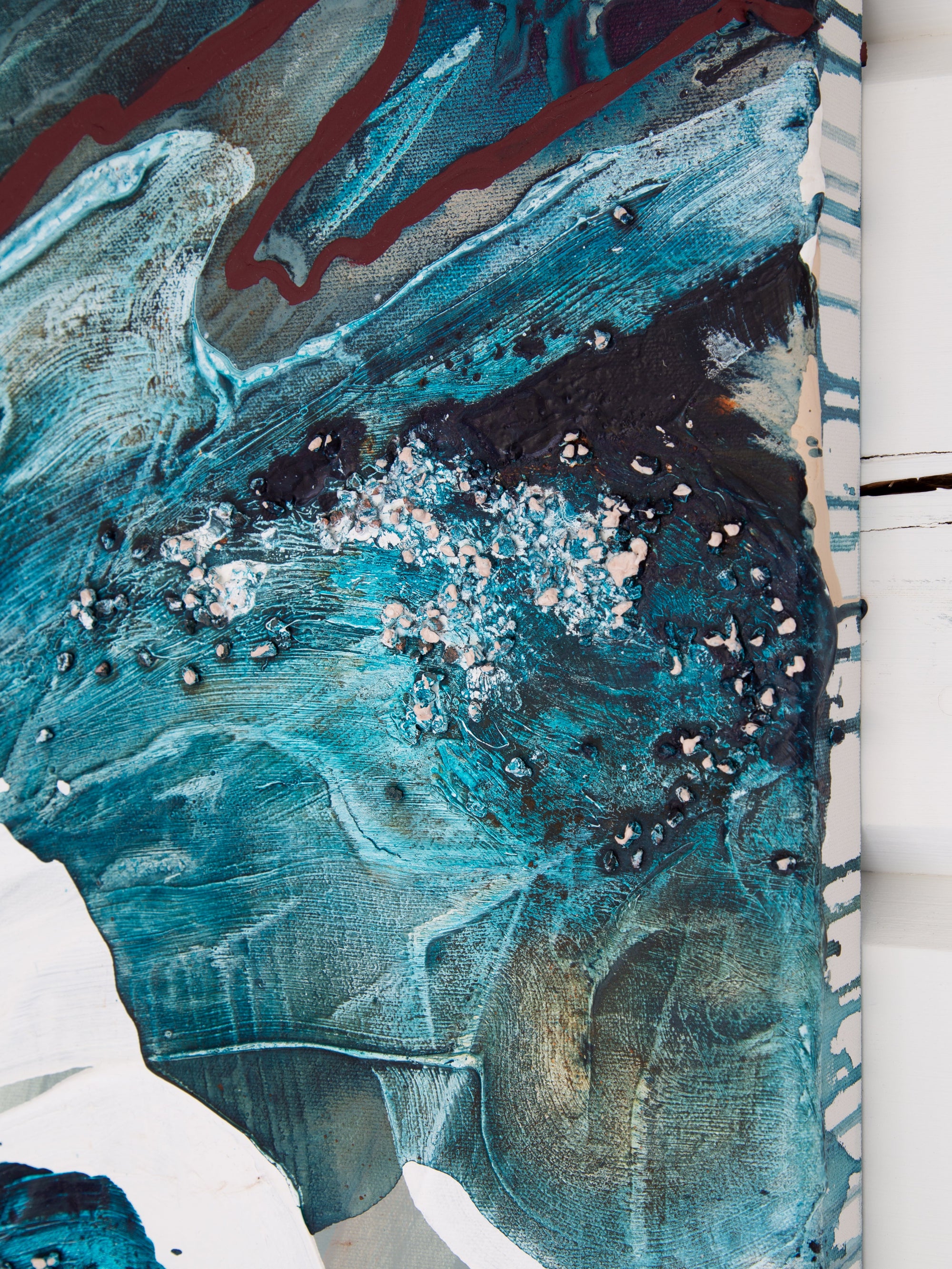 Abstract art piece with blue, black, and white colors on a textured surface.