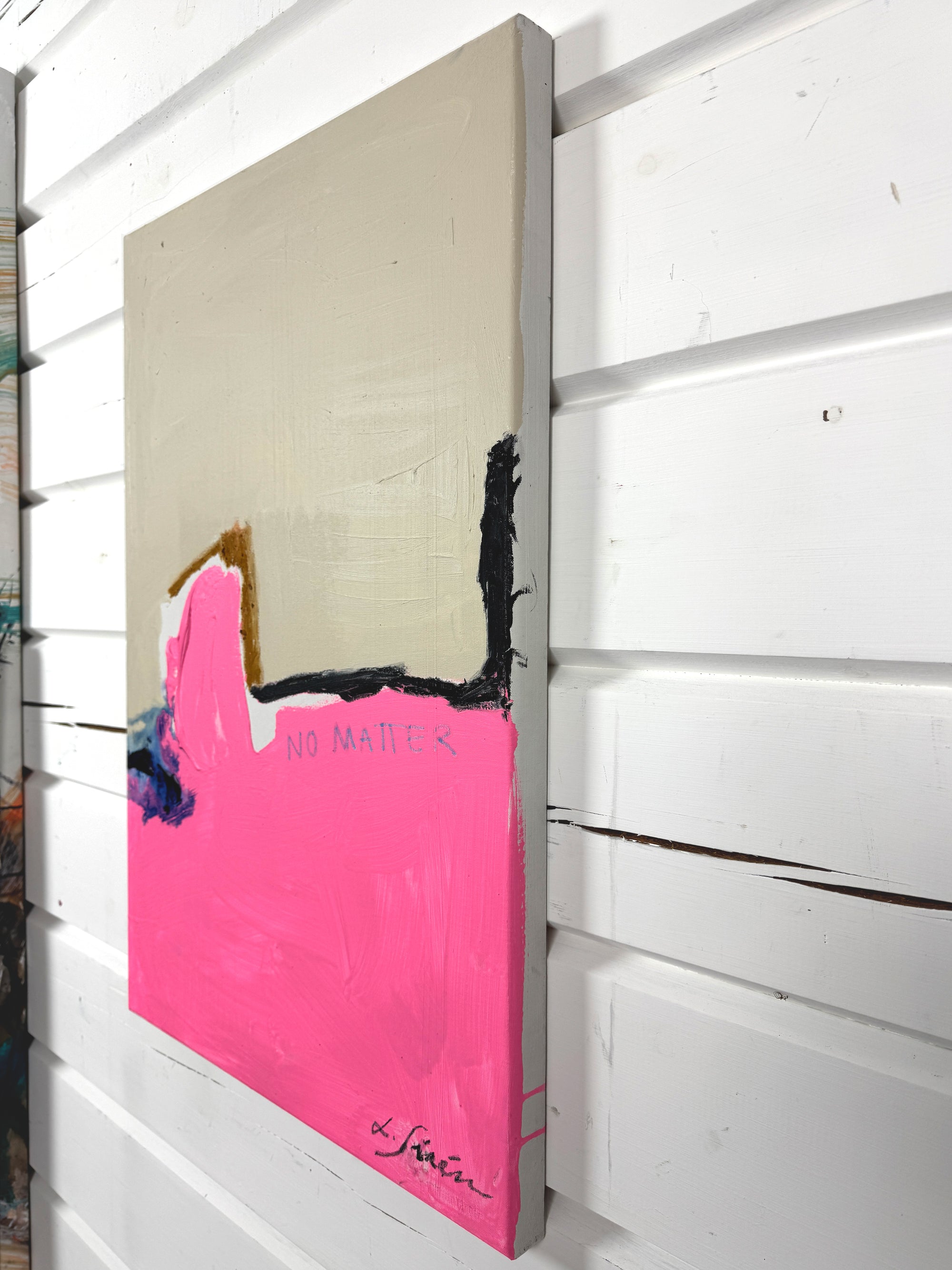 A side of an abstract painting with pink and black elements on a white wall