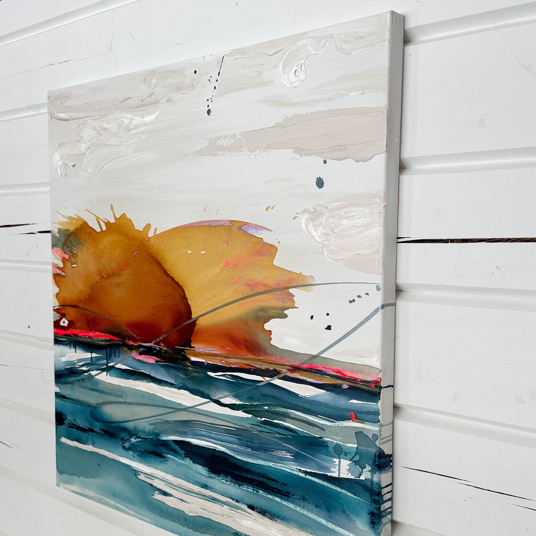 Abstract art piece with orange and blue colors on a white wooden panel.