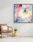 UFO (& other flying vehicles) - Canvas Print. A semi-abstract canvas print with black frame on a wall. A light piece with off-white, pastel tones and blue, pink and yellow hues.  