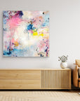 UFO (& other flying vehicles) - Canvas Print. A semi-abstract canvas print on a wall on top of a TV-stand. A light piece with off-white, pastel tones and blue, pink and yellow hues.  