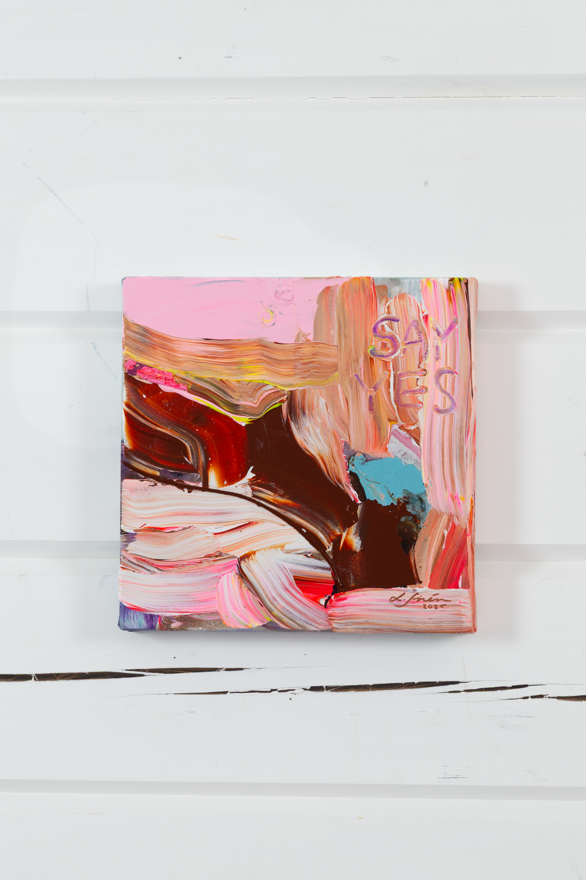 Colorful abstract painting on a white wooden surface