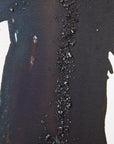Close-up of a textured black surface with small texture on an abstract painting