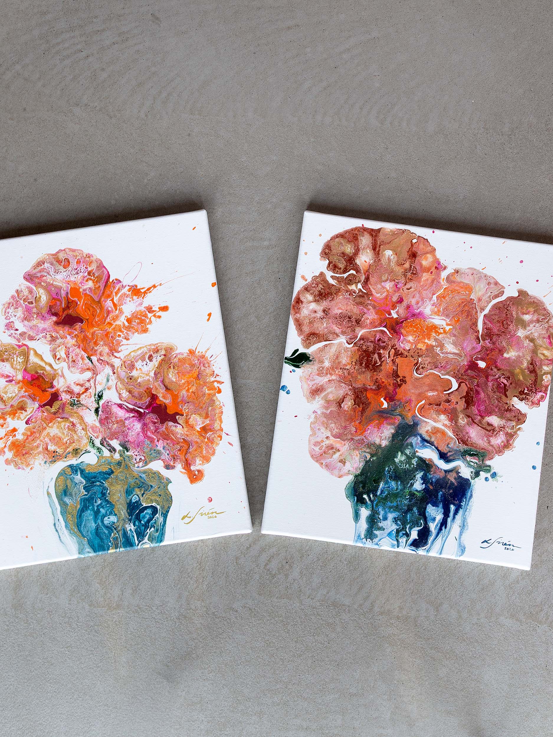 Two semi-abstract floral acrylic paintings on a concrete surface