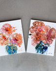 Two semi-abstract floral acrylic paintings on a concrete surface