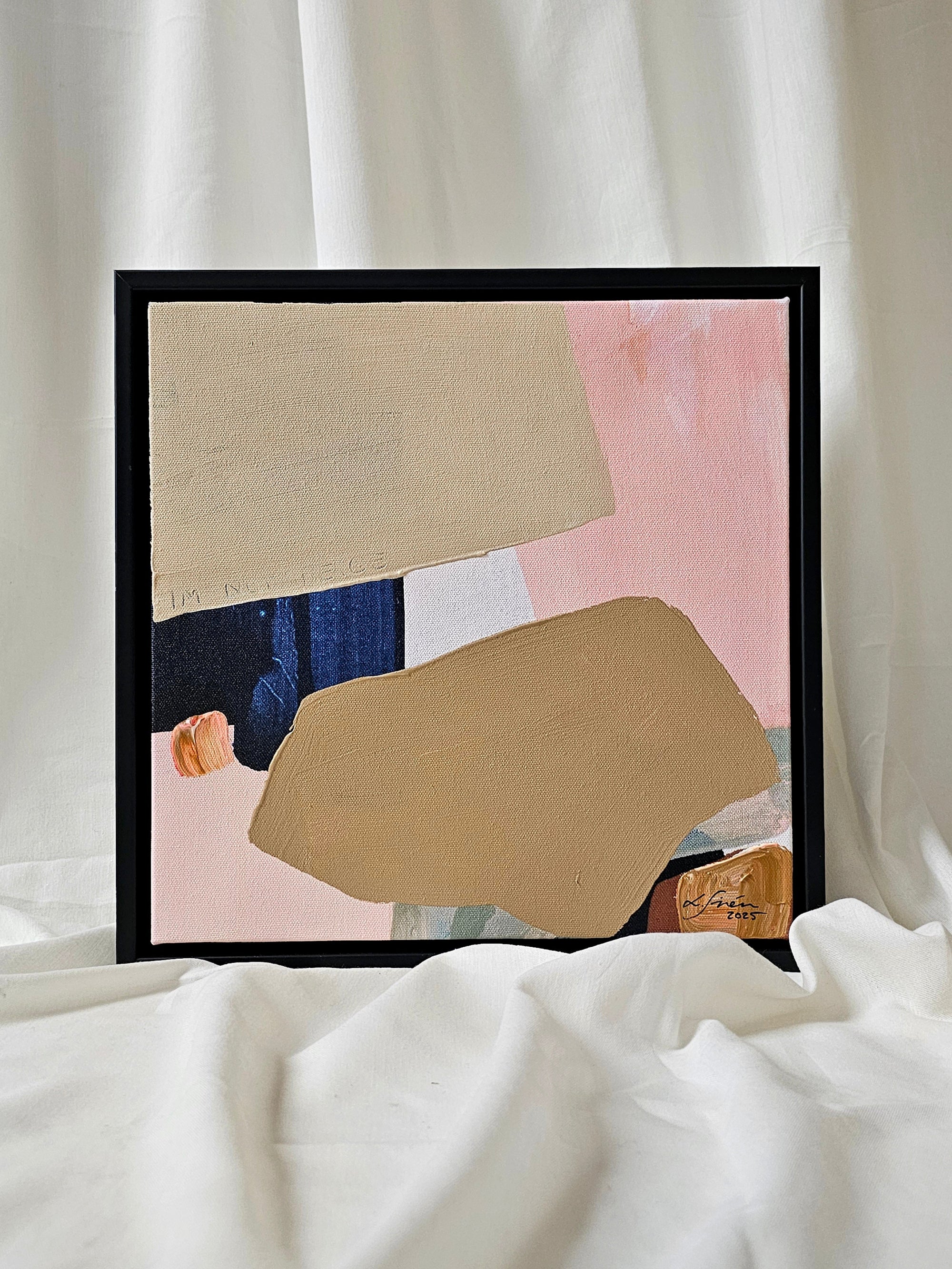 Framed abstract art piece on a white surface