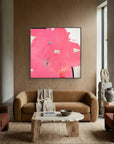 Modern living room with a pink abstract painting on a wooden wall.